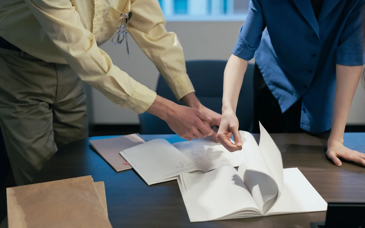 Two people going over printed proofs together at a desk