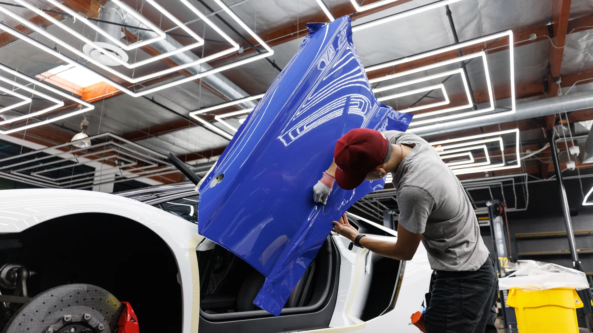 An installer laying vinyl onto a van panel