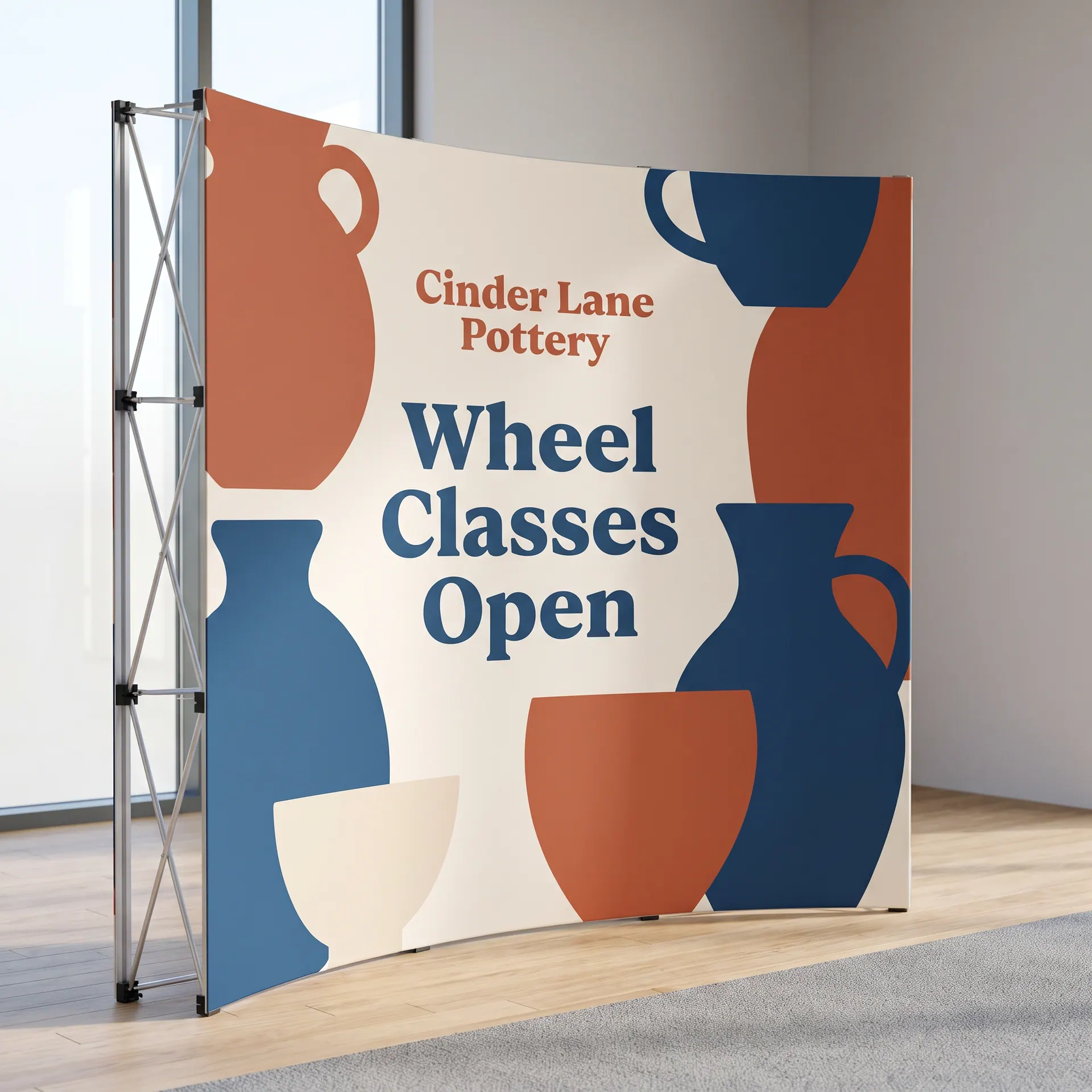 Curved accordion-frame pop-up display with printed fabric panels attached by hook and loop, shown with a sample design: at a trade show booth